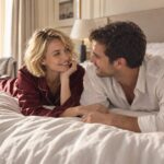 Couple européen blond et brun partageant un moment complice sur un lit