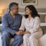 Couple adulte en tenue de nuit partageant un moment tendre et complice sur un lit